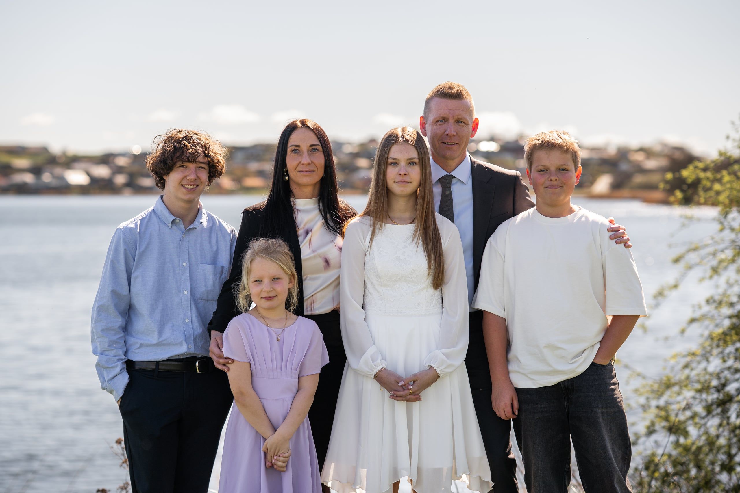 Hele familien samlet ved vandet en solrig dag